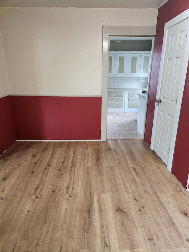 unfurnished room with wainscoting and light wood-style floors