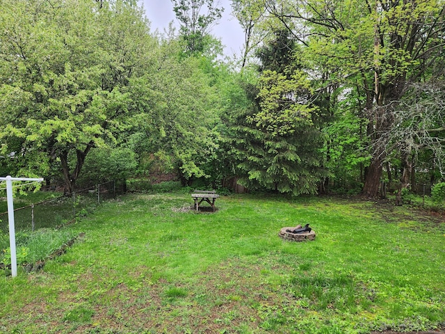 view of yard with an outdoor fire pit and fence