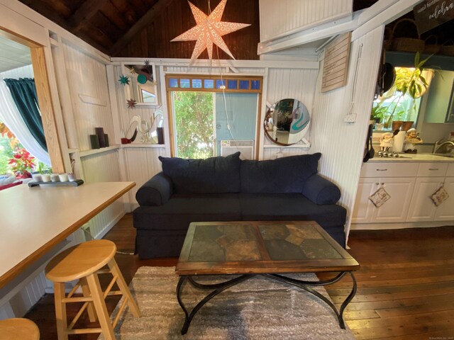 living area featuring vaulted ceiling, wooden walls, wooden ceiling, and dark wood-type flooring