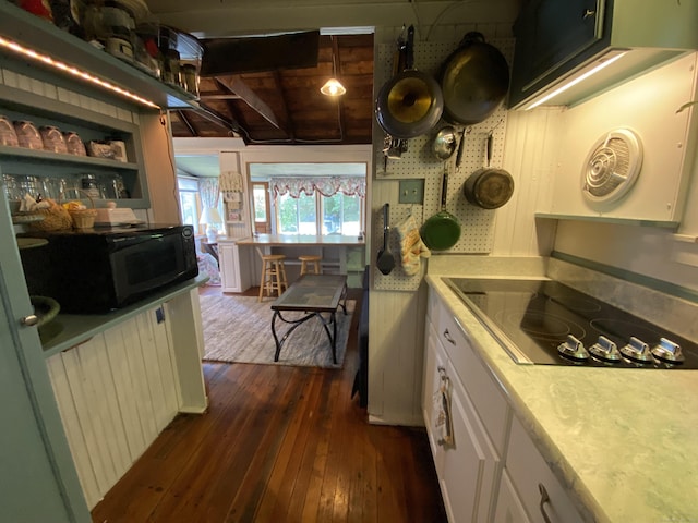 kitchen with white cabinets, light countertops, black appliances, and dark wood finished floors