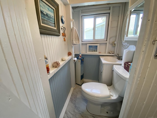 bathroom with toilet, marble finish floor, and vanity