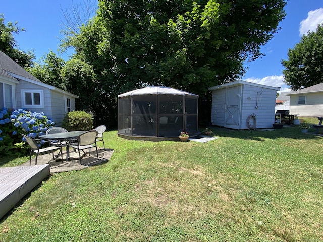 view of yard featuring an outbuilding, a wooden deck, and a storage unit