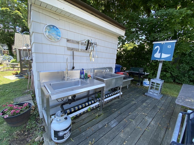 wooden terrace with a sink and grilling area