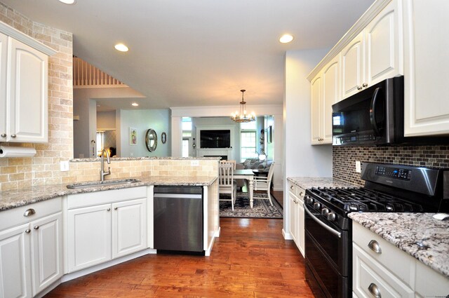 6 Brookside Dr Unit 6, Middlebury, CT 06762 - kitchen featuring decorative backsplash, dark wood-style flooring, a sink, black appliances, and a peninsula