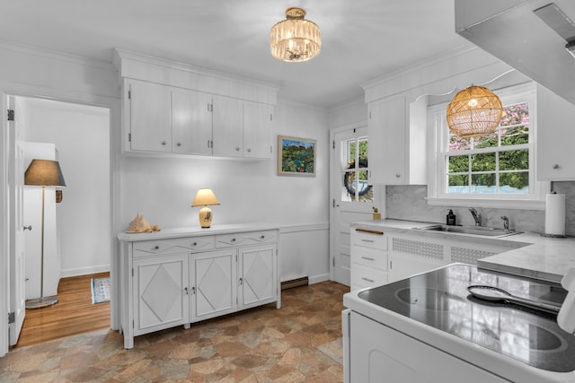 kitchen featuring a notable chandelier, white range with electric stovetop, stone finish flooring, and crown molding