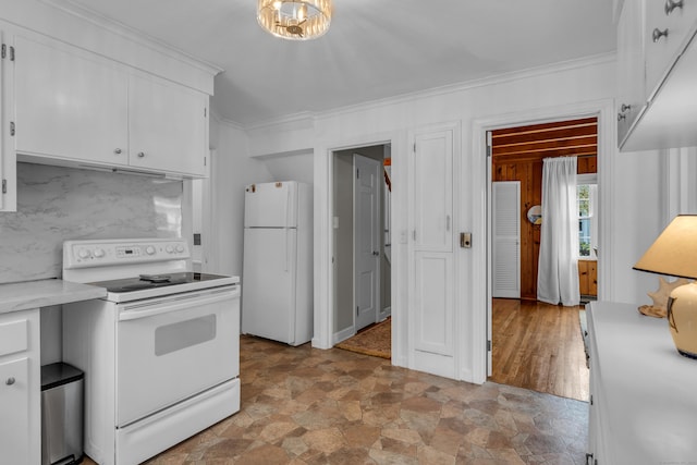 kitchen with white appliances, crown molding, light countertops, stone finish flooring, and white cabinets