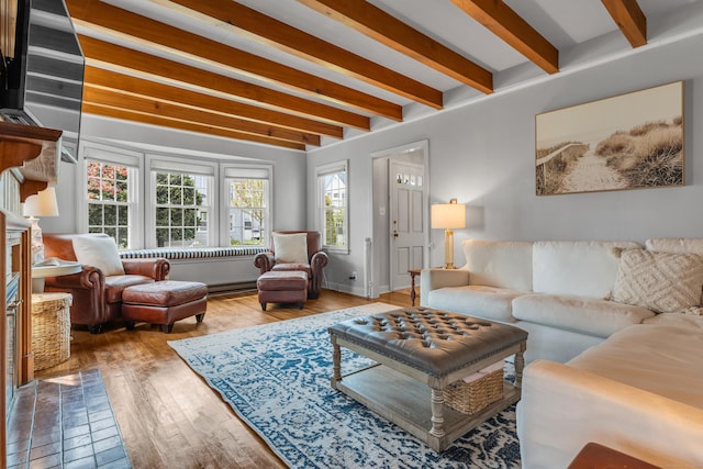 living area with beamed ceiling, baseboards, and wood finished floors