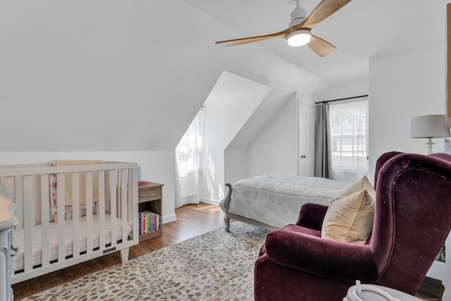 bedroom featuring lofted ceiling, baseboards, a ceiling fan, and wood finished floors