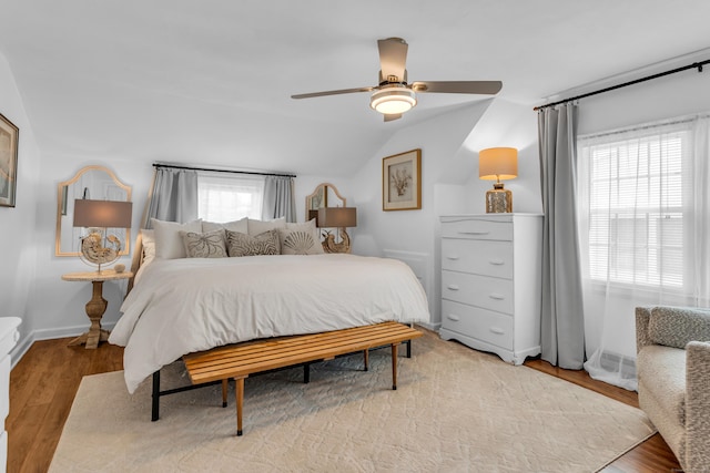 bedroom featuring vaulted ceiling, ceiling fan, baseboards, and light wood-type flooring