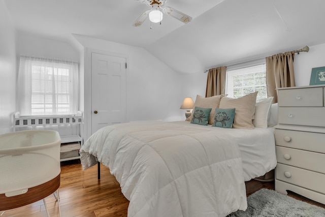 bedroom featuring a ceiling fan, wood finished floors, and vaulted ceiling