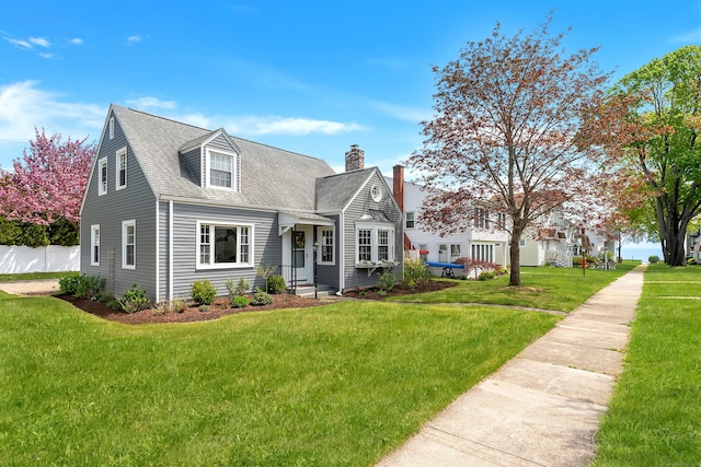 cape cod home featuring a chimney, roof with shingles, a front lawn, and fence