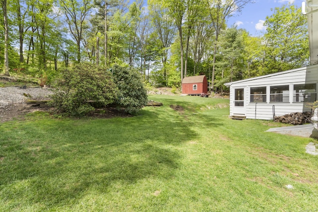view of green lawn with an outdoor structure and a storage unit
