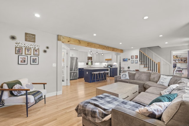 living room featuring recessed lighting, light wood-type flooring, stairway, beam ceiling, and baseboards