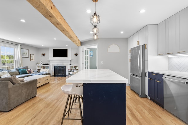 kitchen with stainless steel appliances, blue cabinets, open floor plan, light wood-style flooring, and recessed lighting
