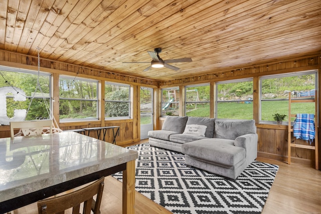 sunroom featuring a ceiling fan, plenty of natural light, and outdoor dining area