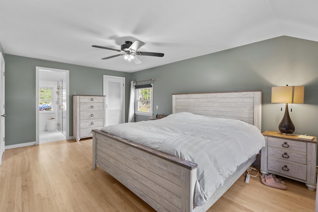 bedroom featuring light wood-type flooring, a closet, connected bathroom, ceiling fan, and baseboards
