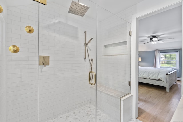 full bath featuring ensuite bath, a shower stall, a ceiling fan, and wood finished floors
