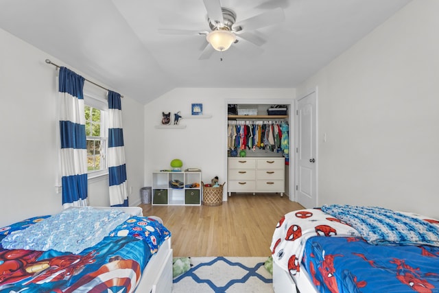 bedroom with wood finished floors, a closet, vaulted ceiling, and a ceiling fan