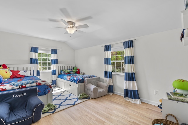 bedroom featuring lofted ceiling, wood finished floors, baseboards, and ceiling fan