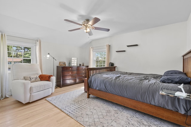 bedroom featuring light wood-style flooring, lofted ceiling, and ceiling fan