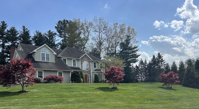 view of front of house with a front lawn and stone siding