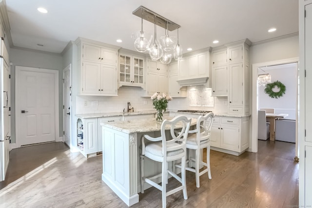 kitchen with a notable chandelier, a center island, recessed lighting, white cabinetry, and tasteful backsplash