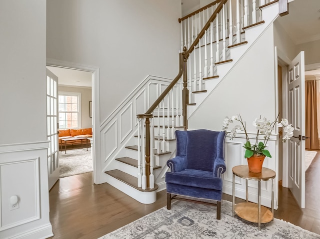 staircase featuring a high ceiling and wood finished floors