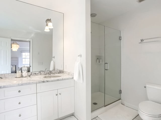 full bath featuring a stall shower, tile patterned floors, vanity, toilet, and ensuite bathroom