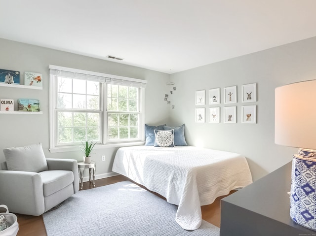 bedroom featuring visible vents and wood finished floors