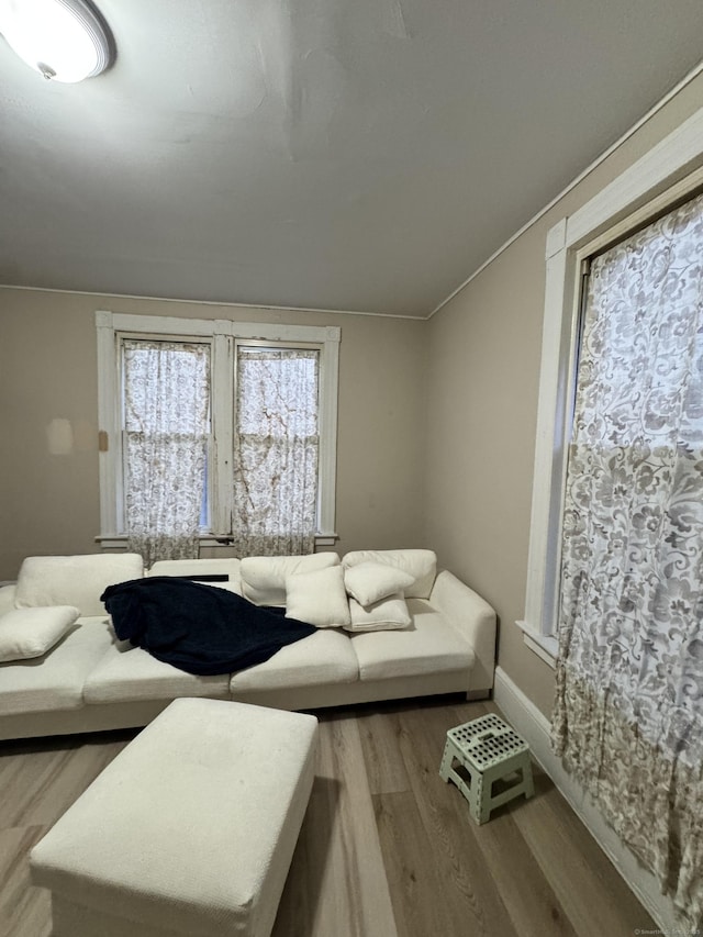 living area with baseboards and wood finished floors