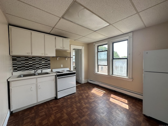 kitchen with a sink, baseboard heating, white appliances, and a paneled ceiling
