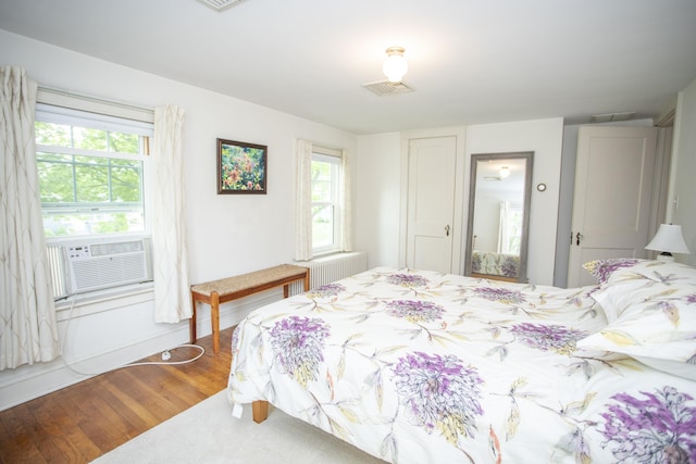 62 Lynde St, Old Saybrook, CT 06475 - bedroom with wood finished floors, radiator, cooling unit, and baseboards