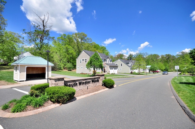 view of asphalt road with traffic signs, curbs, and a residential view