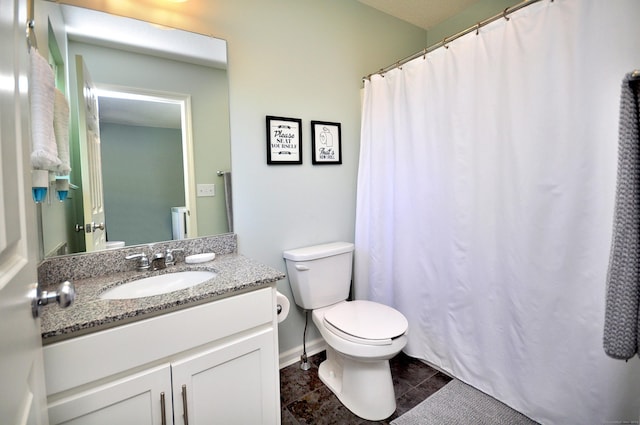 bathroom with toilet, vanity, and baseboards