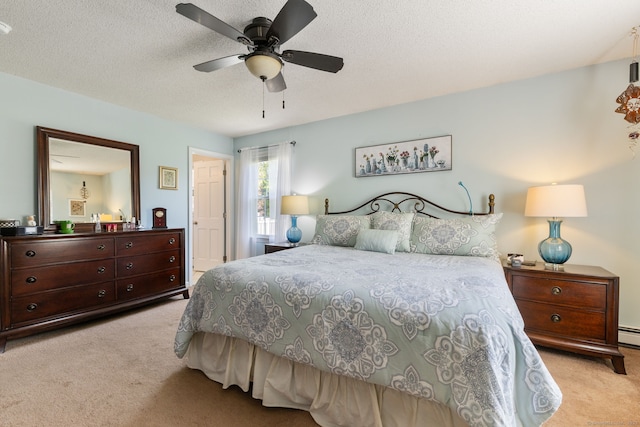 bedroom featuring ceiling fan, light carpet, and a textured ceiling
