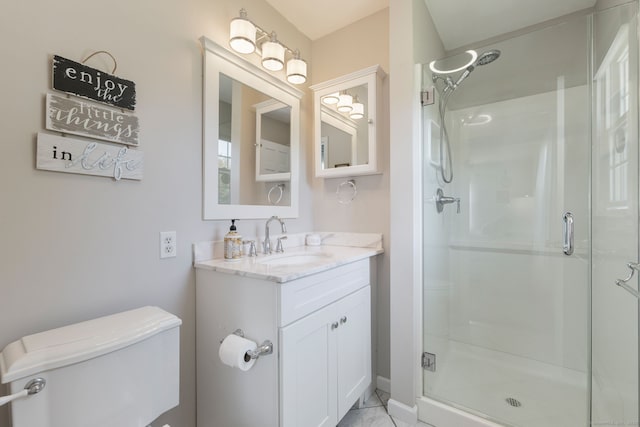 bathroom with vanity, toilet, and a shower stall