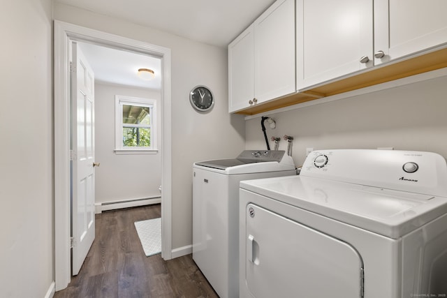 clothes washing area featuring baseboard heating, washing machine and dryer, baseboards, dark wood-type flooring, and cabinet space
