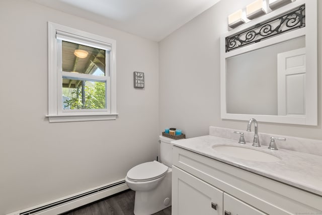 bathroom with toilet, wood finished floors, vanity, and a baseboard heating unit
