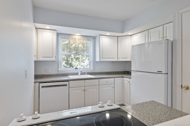 kitchen featuring recessed lighting, white cabinetry, a sink, and white appliances