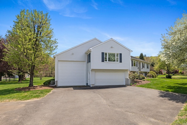 view of front of house with aphalt driveway and a front lawn
