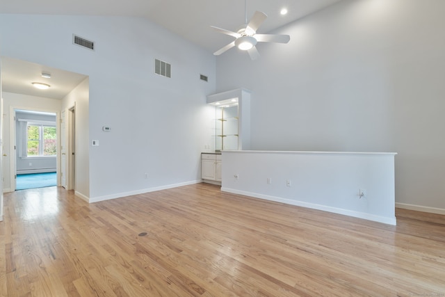 spare room featuring a ceiling fan, light wood-type flooring, visible vents, and high vaulted ceiling