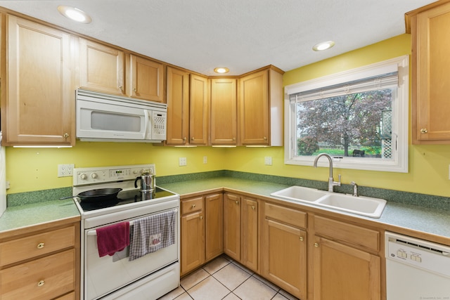 kitchen with white appliances, a sink, light tile patterned flooring, and recessed lighting