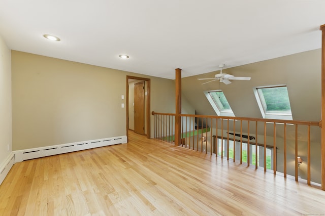 unfurnished room featuring a ceiling fan, a skylight, wood finished floors, baseboard heating, and recessed lighting