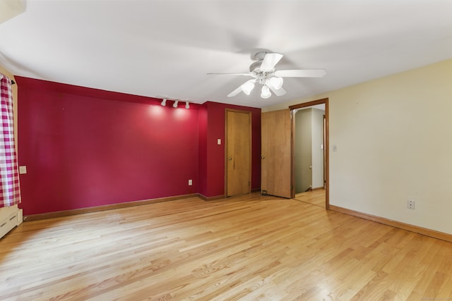 spare room featuring ceiling fan, wood finished floors, and baseboards