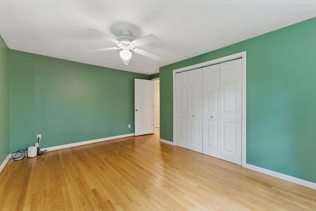 unfurnished bedroom with baseboards, light wood-type flooring, and a closet