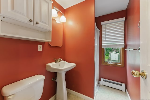 full bath featuring a baseboard heating unit, toilet, baseboards, a shower with curtain, and a sink
