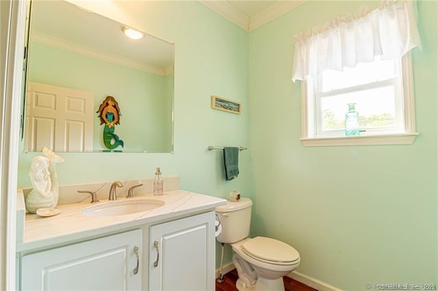 half bathroom with crown molding, baseboards, toilet, and vanity