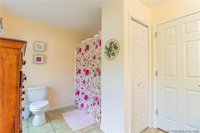 full bathroom with baseboards, tile patterned flooring, toilet, and a shower with shower curtain