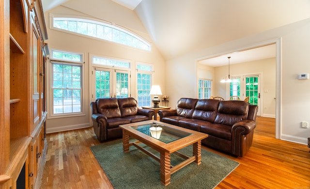 42 N Woods Rd, Hamden, CT 06518 - living area featuring wood finished floors, healthy amount of natural light, a chandelier, high vaulted ceiling, and baseboards