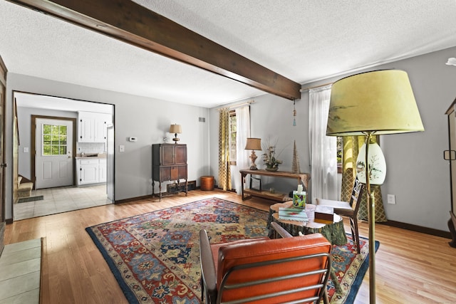 63 Schofield Rd Apt 60, Willington, CT 06279 - living area featuring a textured ceiling, light wood-type flooring, baseboards, and beam ceiling